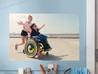 Fotoposter 70×50 cm Gepersonaliseerde fotoposter met een foto van twee lachende vriendinnen, een zit in een rolstoel en de andere duwt de rolstoel
